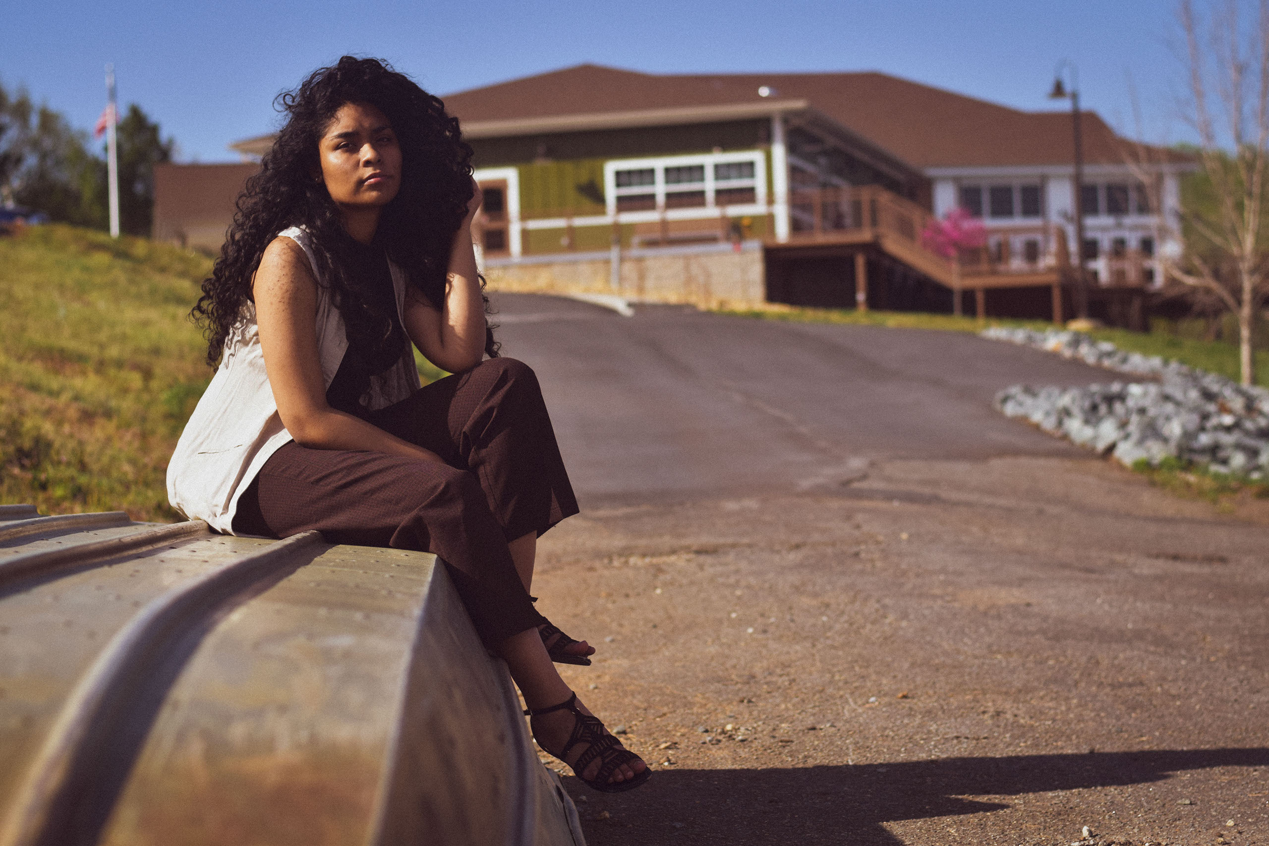 A woman sits on an overturned boat while looking at the camera